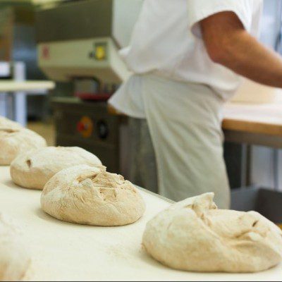 baker baking fresh bread in the bakehouse.